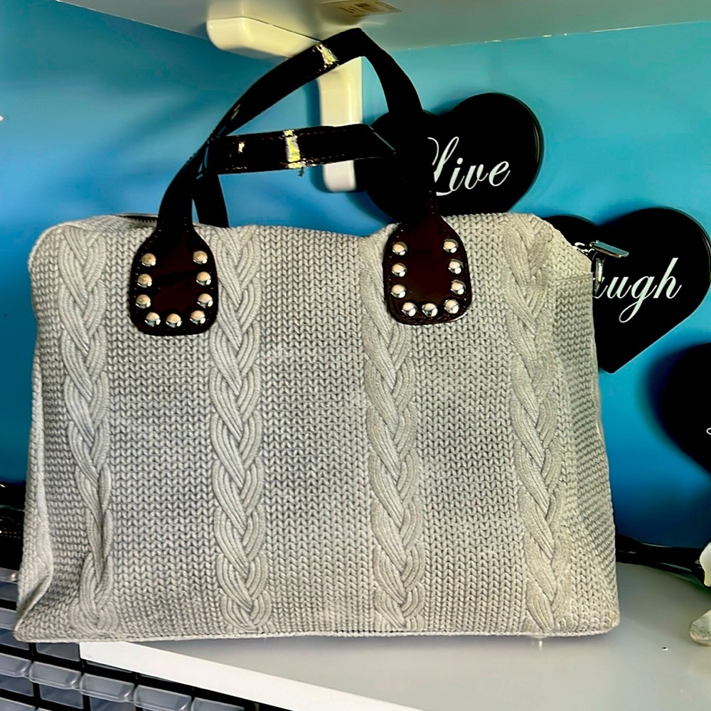 gray cable knit looking handbag that is gray in color- shoulder strap included.